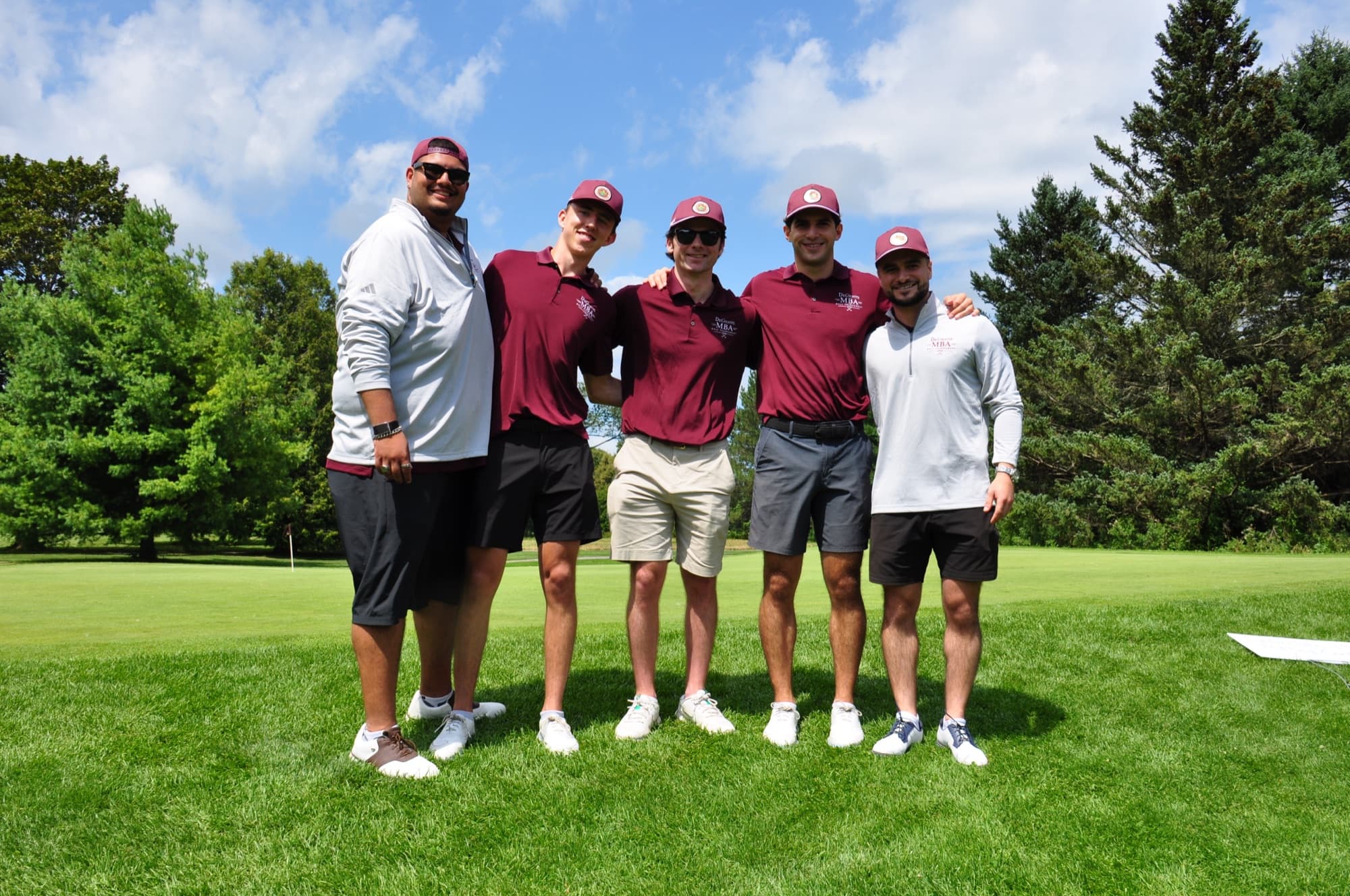 The five founding committee members standing shoulder to shoulder on a green